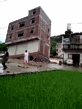 广西楼房暴雨倒塌 男子楼前围观全程