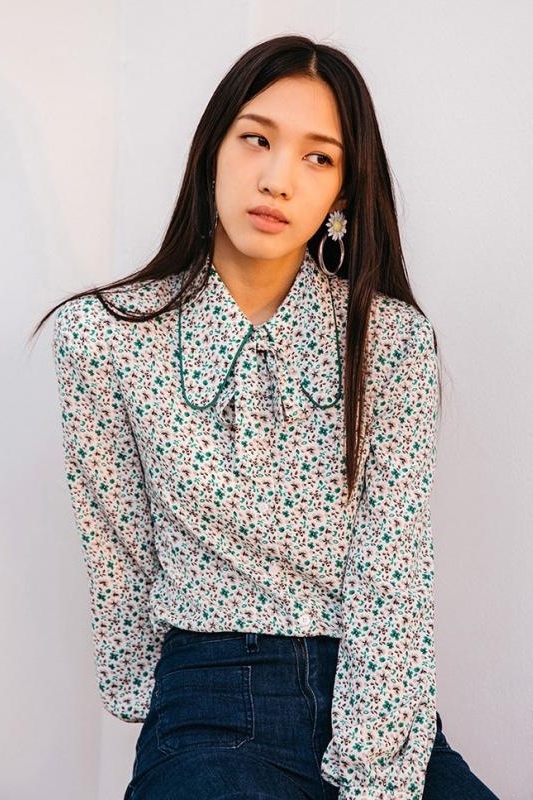 少女身穿白色一字领绣花上衣搭配牛仔半身裙,